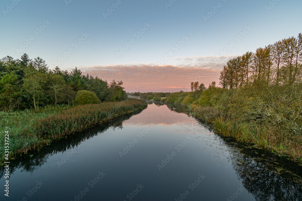 Clear sky morning on Inny river with reflections of sky, trees.