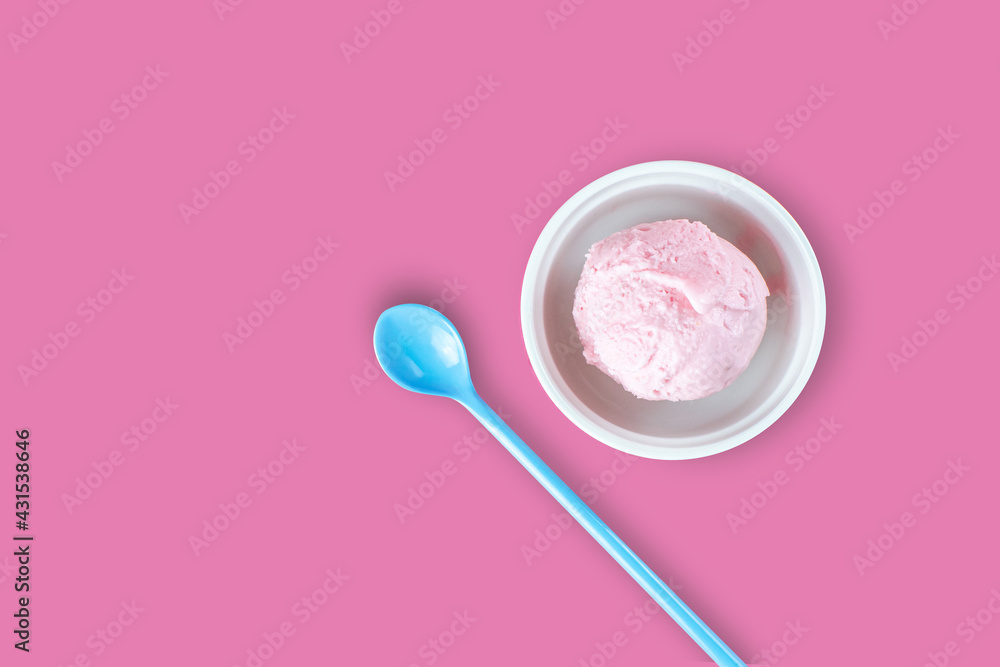 White cup of strawberry icecream and blue spoon serving on isolated pink background with blank copy space. Food, Dessert and advertisement Concept. White cup of strawberry icecream and blue spoon serving on isolated pink background with blank copy space. Food, Dessert and advertisement Concept.