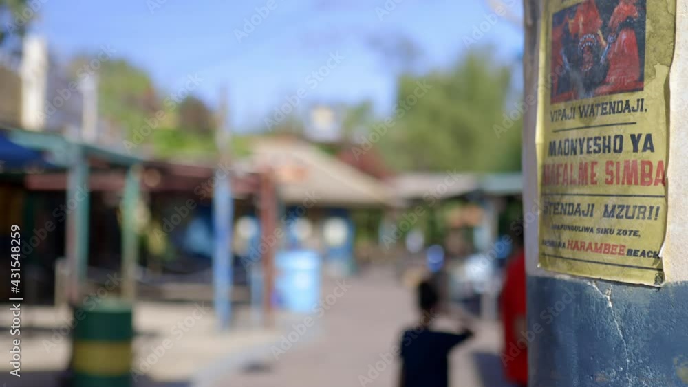 Small blurry buildings, people, and blue sky behind wall Small blurry buildings, people, and blue sky behind wall