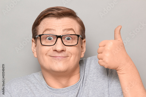 Portrait of funny happy mature man raising thumb up and smiling