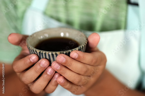 Barista Waitress offering a cup of coffee in cafe. show hand and ceramic cup .Selective Focus Blur Background
