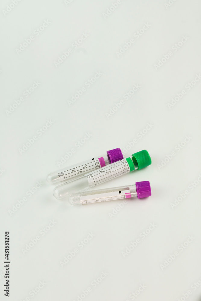 vacuum tubes for collection and blood samples on white background..Transparent with purple and green lid. Label to identify the data. Selective focus. vacuum tubes for collection and blood samples on white background..Transparent with purple and green lid. Label to identify the data. Selective focus.