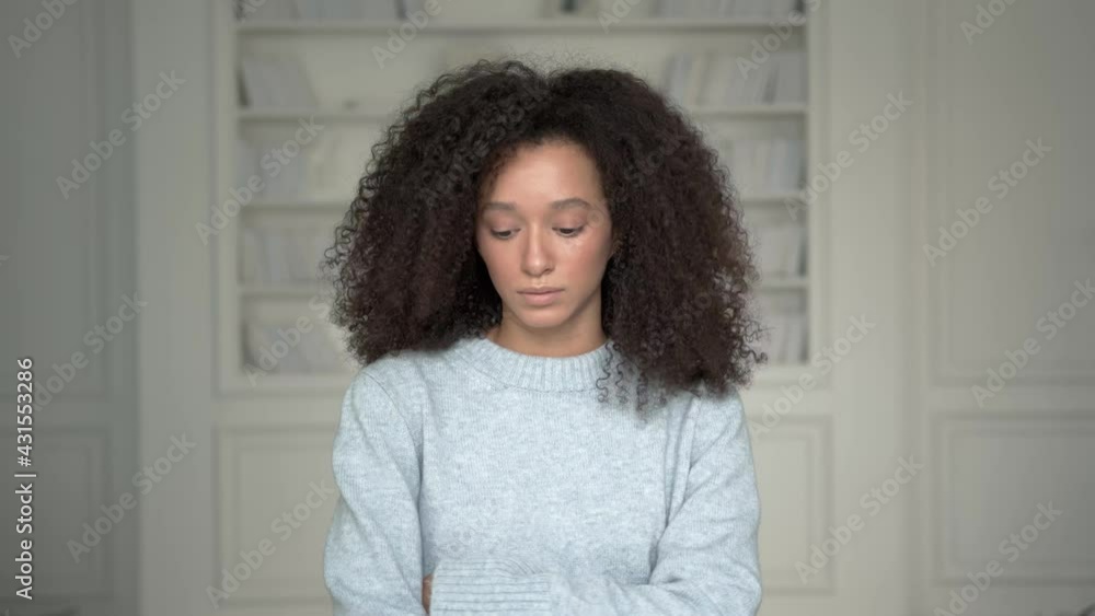 Young american black woman in blue warm sweater with curly hair, middle shot. Afro hairstyle, attractive beautiful woman on white blurred background Young american black woman in blue warm sweater with curly hair, middle shot. Afro hairstyle, attractive beautiful woman on white blurred background