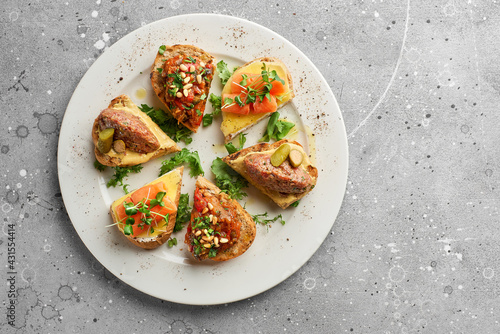 Top view on appetizing italian appetizers bruschettas on a white plate, horizontal