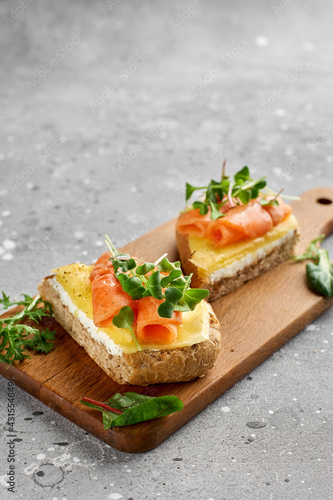 Bruschetta with salmon. Whole grain bread with salmon, cheese on a wooden board. Bruschetta with salmon. Whole grain bread with salmon, cheese on a wooden board.