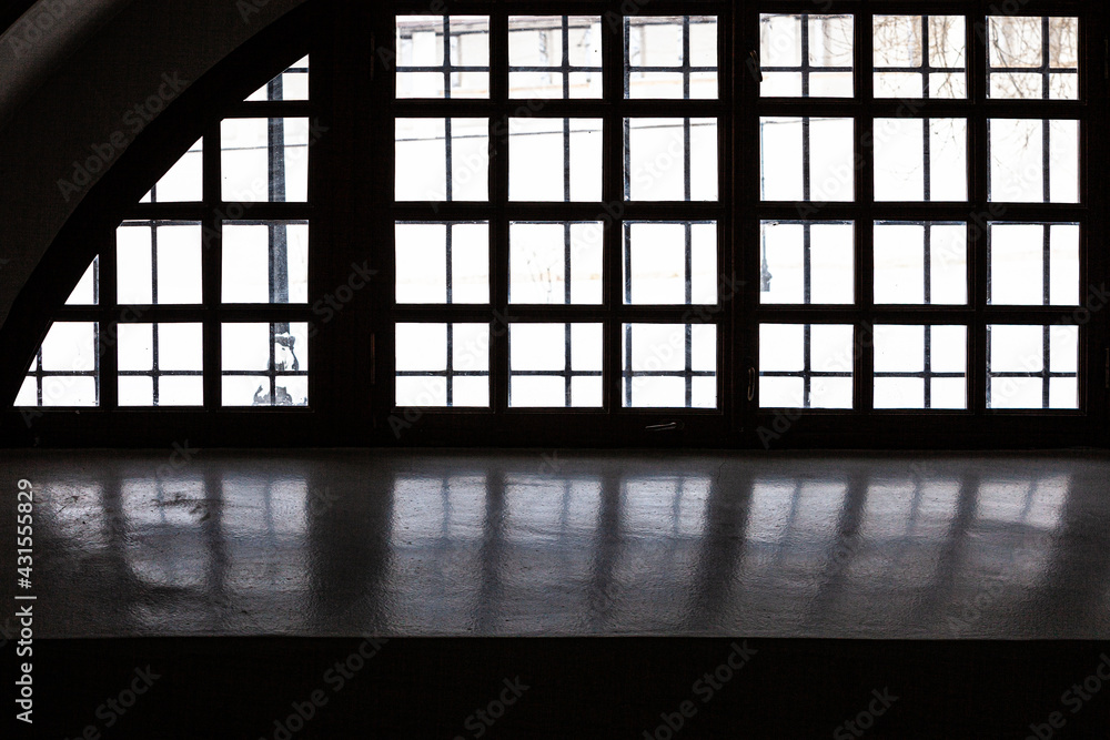 Arch window grill reflected in a windowsill in low light Stock Photo