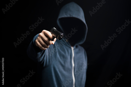 holding a gun on a dark background