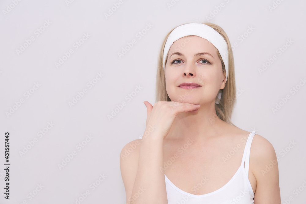 middle-aged woman makes self-massage of the face, exercise to get rid double chin middle-aged woman makes self-massage of the face, exercise to get rid double chin