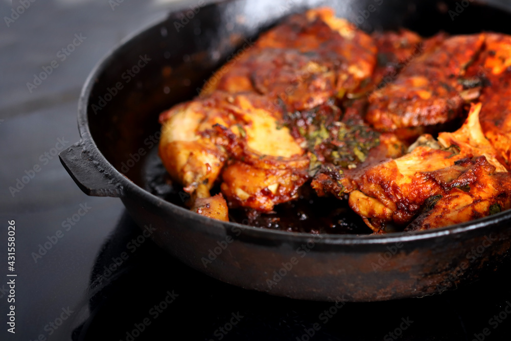 Appetizing grilled chicken in a cast iron pan.