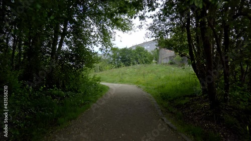 traveling on a brown dirt trail with green vegetation and clear sky. country road through the forest next to the river
