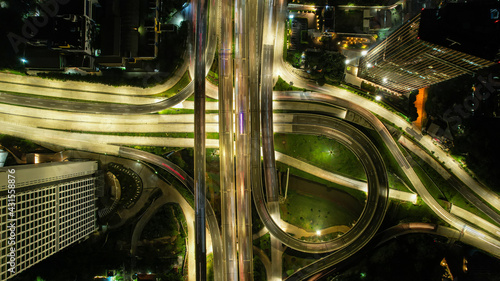 Aerial view of the city traffics at the Jakarta at night. Vehicles are moving on the road between buildings. Jakarta, Indonesia, May 4, 2021