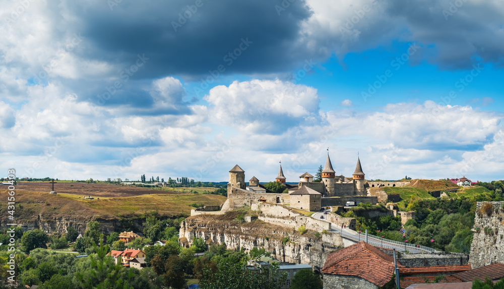 Medieval Towers and fortress walls of Old Kamianets-Podilskyi Castle in Old Kamianets-Podilskyi town, Ukraine. Panoramic summer view of old famous Ukrainian Castle and picturesque nature landscape