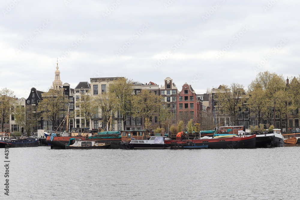 Amsterdam Oosterdok View with Historical House Facades, Boats and Spring Trees 