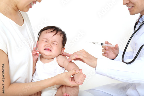 白背景で注射をされ泣く新生児。予防接種イメージ