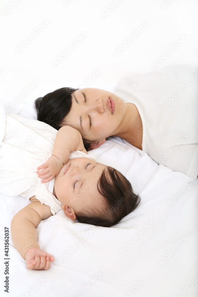 新生児と一緒に昼寝するお母さん。育児疲れイメージ 新生児と一緒に昼寝するお母さん。育児疲れイメージ