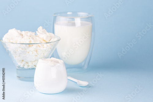 Glass of milk, cottage cheese and sour cream on a blue