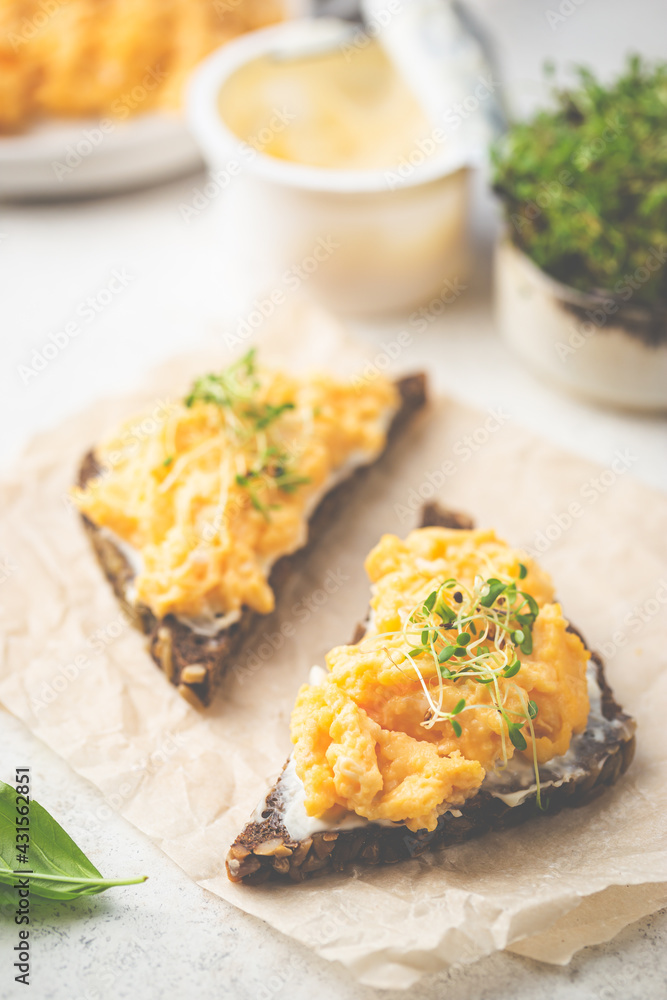 Scrambled egg sandwich with cream cheese on rye toast for breakfast on white background. Healthy breakfast or snack Scrambled egg sandwich with cream cheese on rye toast for breakfast on white background. Healthy breakfast or snack