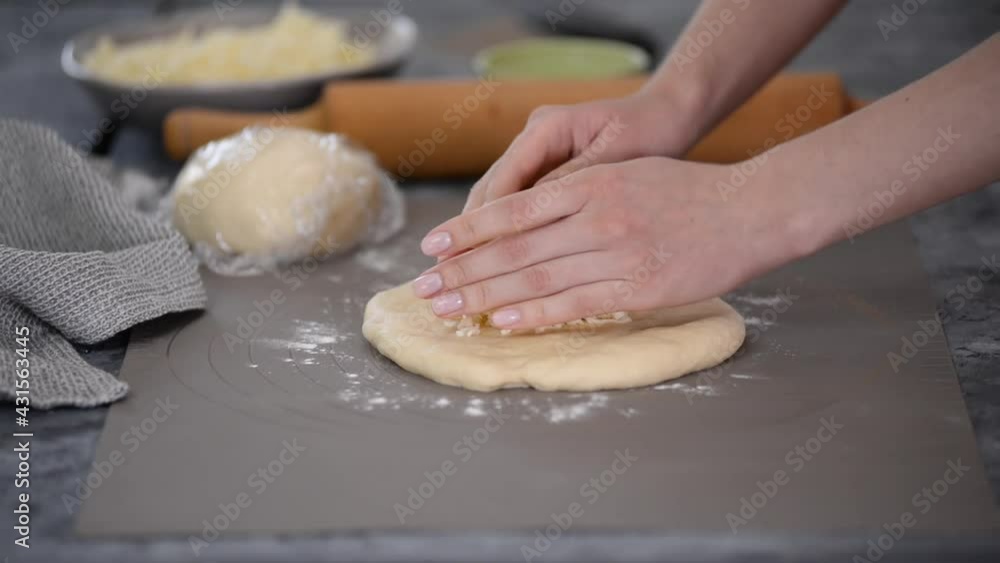 Close-up hands of female baker preparing traditional Georgian cuisine khachapuri. Close-up hands of female baker preparing traditional Georgian cuisine khachapuri.