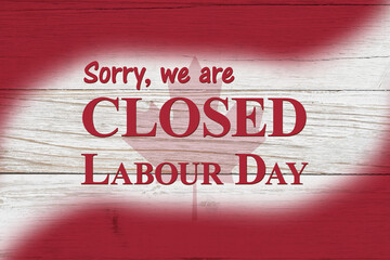 Closed Labour Day message with Canadian maple leaf flag on wood