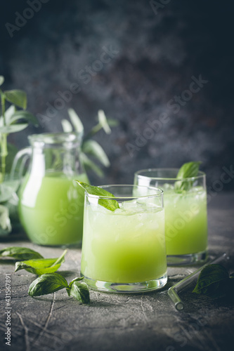 Cold basil lemonade refreshing summer drink on gray background