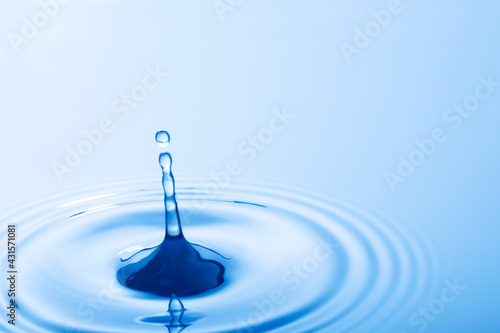 Drop of water. Water droplet falling impact with water surface. causing rings on water surface..