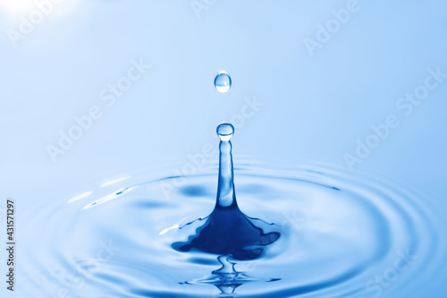 Drop of water. Water droplet falling impact with water surface. causing rings on water surface..