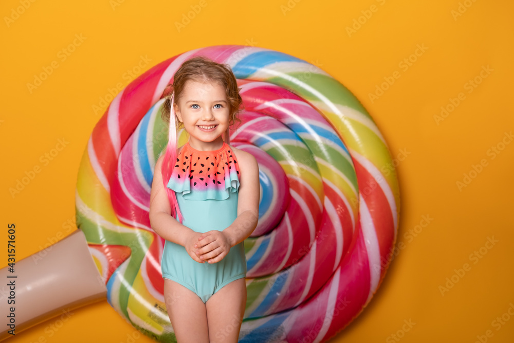 Funny little girl in swimming suit smiling having fun on yellow background. Funny little girl in swimming suit smiling having fun on yellow background.