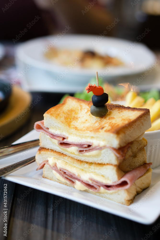 Close-up of sandwich ham cheese served with BBQ Pork Ribs and pasta cheese on table.