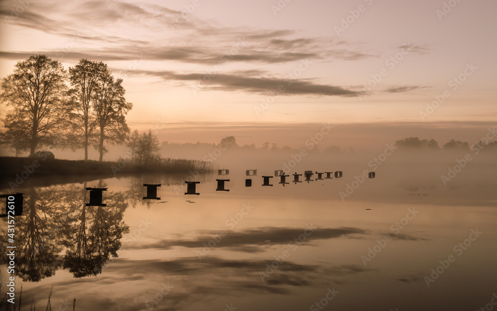 unset on the lake in the evening with fog.