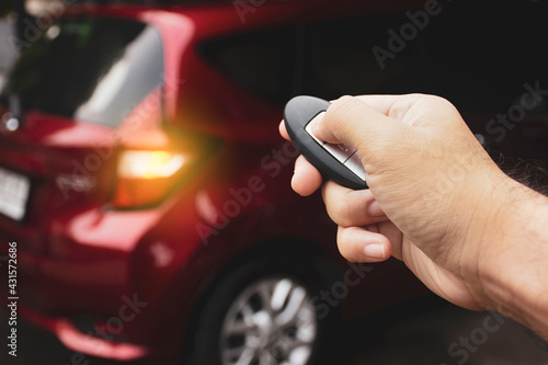Human hand is pressing lock or unlock button of the car keyless remote