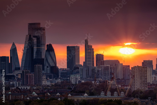 The skyline of the City of London with the modern office skyscrapers shining in the red sunset light