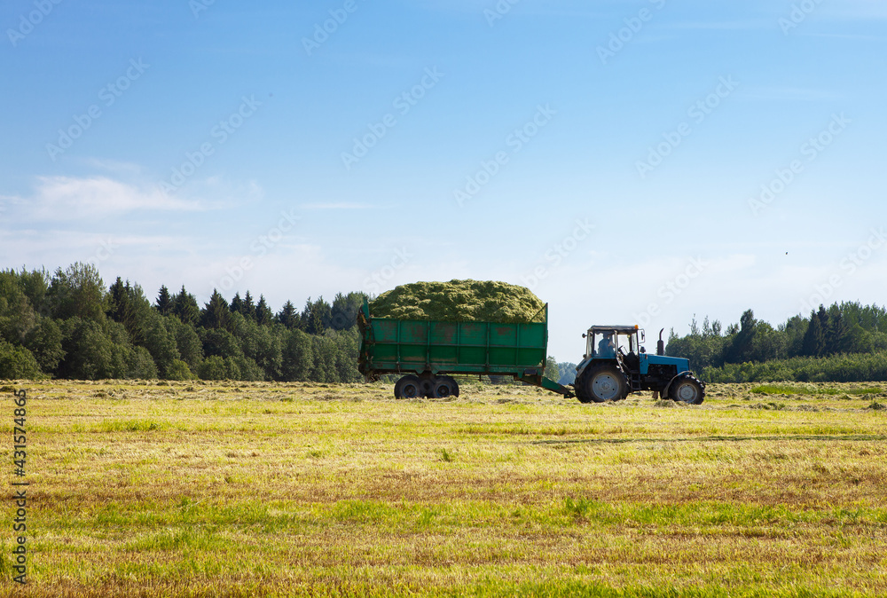 Obraz premium Tractor with a trailer in the field for agricultural work.