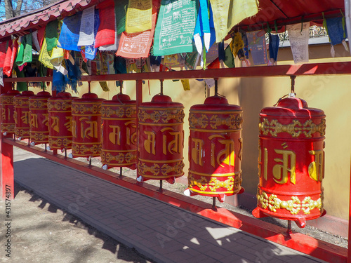 buddhist prayer drums in red with gold characters