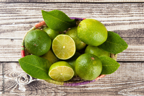 Fotografie Green lime fruit in basket with top view