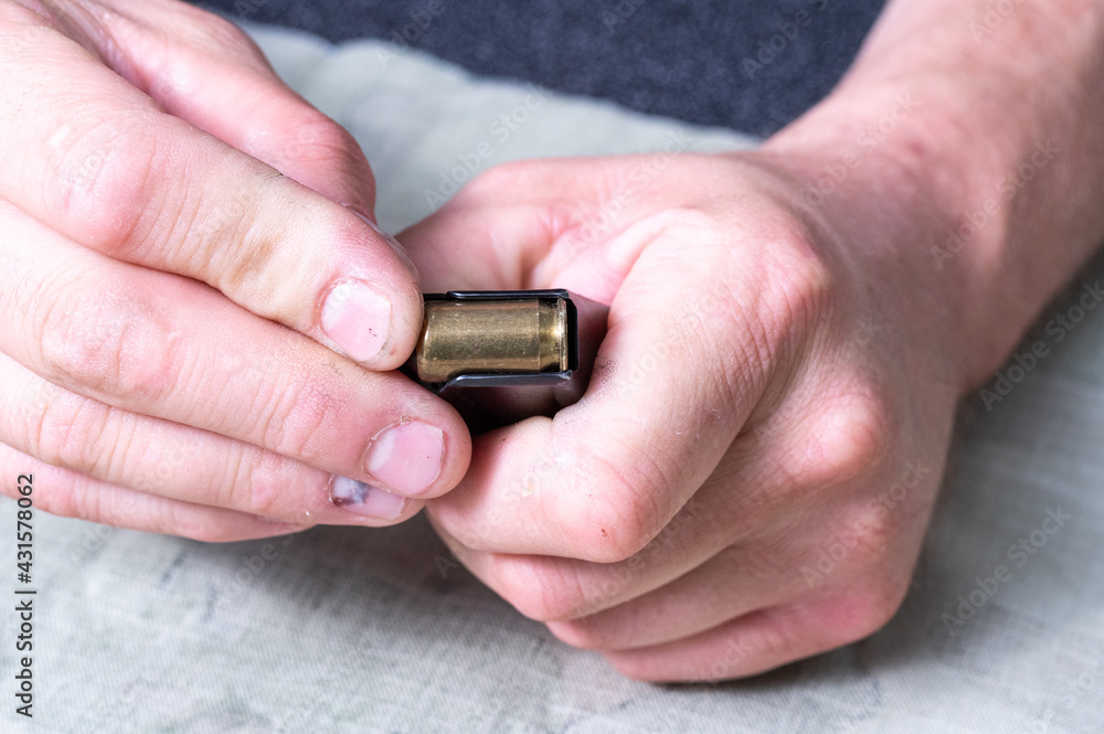 Insert the cartridge into the pistol magazine. The cartridge is in the hands. Insert the cartridge into the pistol magazine. The cartridge is in the hands.