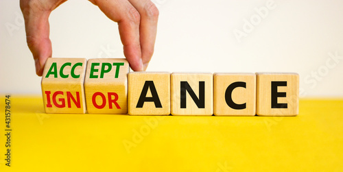 Acceptance or ignorance symbol. Businessman turns cubes, changes the word 'ignorance' to 'acceptance'. Beautiful yellow table, white background. Business, acceptance or ignorance concept. Copy space.