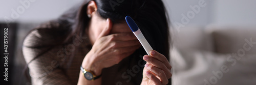 Tableau sur toile Sad woman holding pregnancy test in her hand