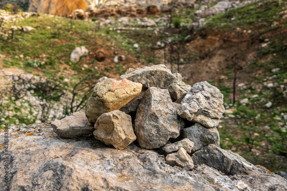 Small pile of stones on a rock, and with a natural landscape in the background. Small pile of stones on a rock, and with a natural landscape in the background.