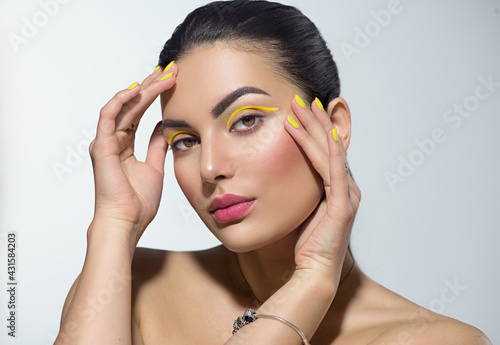 Obraz na płótnie Beauty model girl with fashion make-up, Bright yellow eye line and nails, trendy manicure