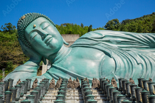 Nazoin Buddhist Temple with Reclining Buddha. Blue skies and turquoise statue lying on it's side. Longest Buddha in the world. Fukuoka, Japan © Red Pagoda