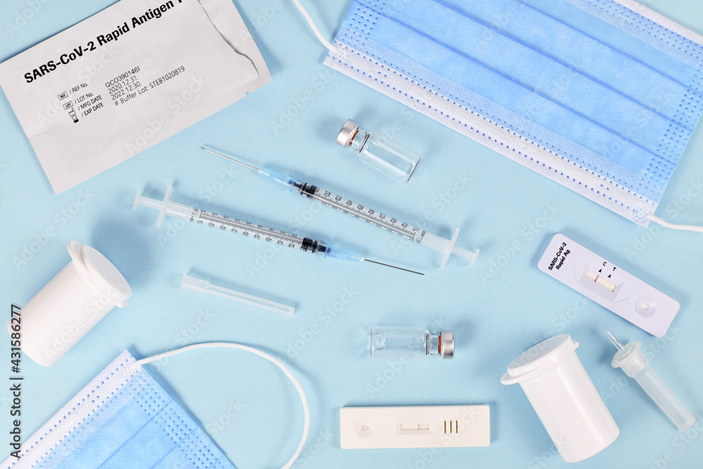 Fight Corona Virus pandemic with tools like rapid antigen test , medical face masks and vaccine vials with syringe Fight Corona Virus pandemic with tools like rapid antigen test , medical face masks and vaccine vials with syringe