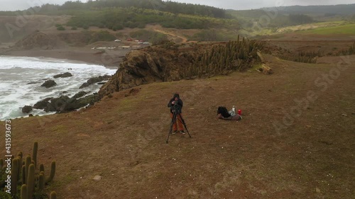 surf and nature photographer on the coast of chile, pacific ocean, pichilemu punta de lobos, drone footage, orbital plane