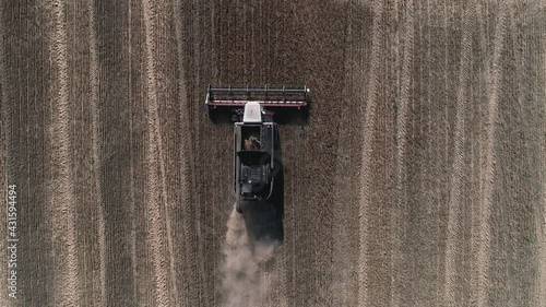 Flying over the harvester driving across the field