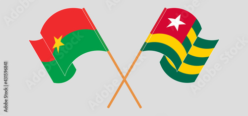 Crossed and waving flags of Burkina Faso and Togo