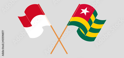 Crossed and waving flags of Monaco and Togo