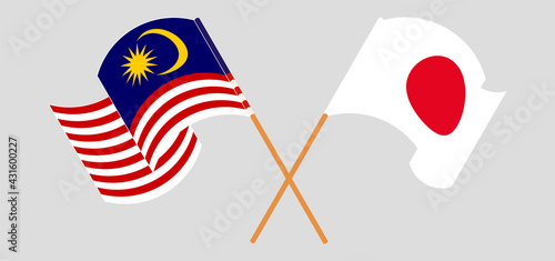 Crossed and waving flags of Malaysia and Japan