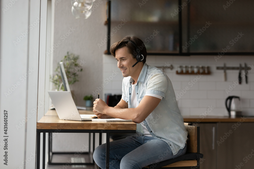 Smiling young Caucasian man in earphones talk speak on video call on laptop, study online at home. Happy male in headphones look at computer screen have webcam virtual zoom meeting or conference. Smiling young Caucasian man in earphones talk speak on video call on laptop, study online at home. Happy male in headphones look at computer screen have webcam virtual zoom meeting or conference.