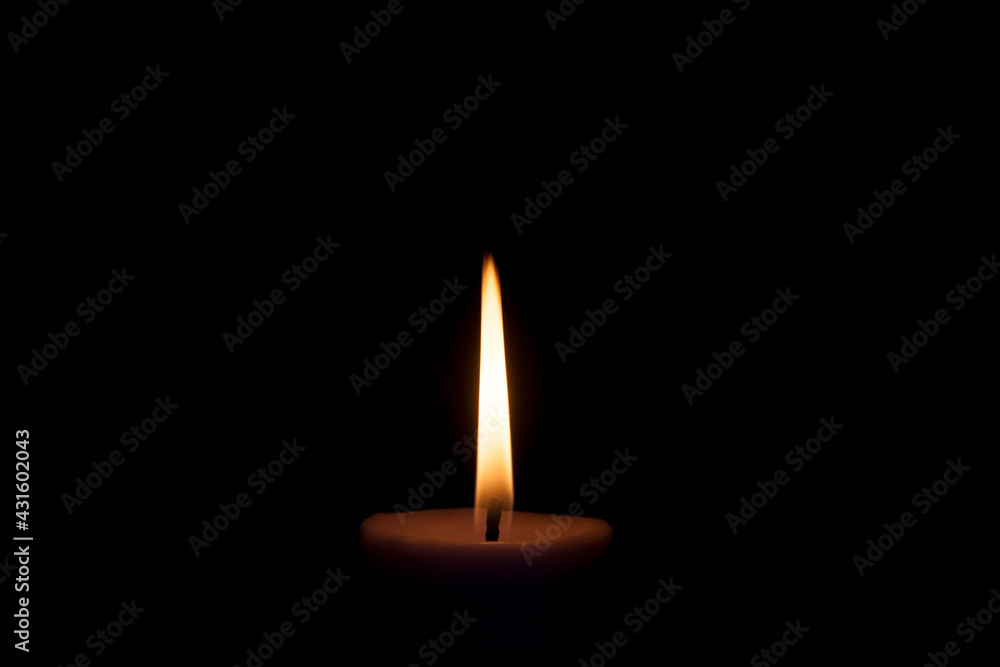 Candle flame on a dark background. White candles burning in the dark. By candlelight. Candle flame on a dark background. White candles burning in the dark. By candlelight.
