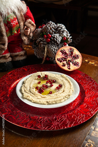 Traditional Middle Eastern food. Lebanese food. Arabian Hummus with Pomegranate seeds and Christmas decoration