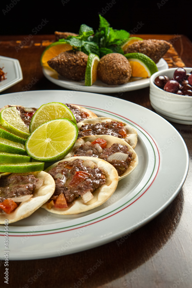 Traditional Middle Eastern food. Lebanese Sfiha meat. Arabian sfeeha plate. Esfiha with lemons. Kibbeh Kibe